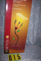 Photo of the tall rectangular box showing the image of the flower uplight lamp with colorful beads on a yellow-orange background with the Portfolio brand name.