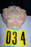 Full view of pink-toned vintage jewelry box made of carved Incolay stone, showing size proportional to lot number cards.