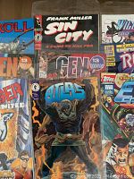 Photo of multiple comic books including Frank Miller's Sin City, Gen 13, Atlas, Vigil, and Rogue.