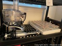 Photo showing Cuisinart hand blender, food processor, and 29 small glass jars in protective foam tray.