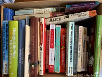 Photo showing a mixed lot of books in a box, spines visible including titles on design, literature and history.