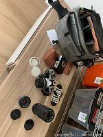 Overview showing Nikon FE body, two Series E lenses, additional zoom lens, filters, leather pouch and padded camera bag.