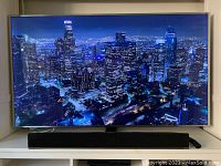 Front view of TV on shelf displaying cityscape image