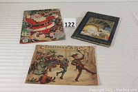 Photo showing three vintage children's Christmas books closed on white surface.