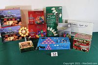 Full lot photo showing all 8 boxes of lights including icicle light sets, multiple boxes of C-9 and C-7 bulbs, a spherical working tree topper on a reflective base, and a boxed rapid light saver device.
