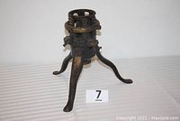 Front and side view of antique cast iron Christmas tree stand with three legs and adjustable collar