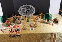Wide view of all Christmas themed items displayed on table including figurines, houses, ornaments, and plate