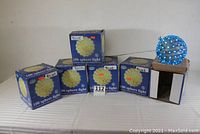 Photo of six boxed blue sphere lights along with one sphere light out of the box showing packaging and quantity.