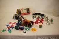 Full view of lot showing flower reflectors, C-7 light set box, blue C-6 string lights, bell ornaments, and clothespins.