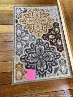Close-up of the doormat showing its multicolored floral abstract pattern and textured surface.