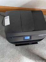 Front and top view of the HP OfficeJet 4655 printer showing its operational display and physical condition.