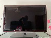 Front view of Samsung flat panel TV showing the screen, bezel and stand.