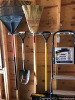 Full view of all five yard tools including plastic rake, broom, square shovel, snow shovel, and step ladder with paint roller set