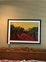 Framed print of Olive Trees by van Gogh in black frame above headboard