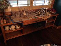 Front view showing the top drawer, two open shelves and overall table design