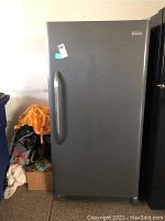 Front view of upright Frigidaire freezer in garage