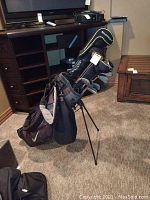 Nike black and grey Golf bag standing with clubs inside, legs extended.