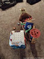 Wide view showing multi-activity cube, blocks, toddler rocker, and container.