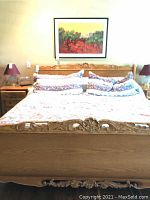 Full frontal view of king size oak sleigh bed showing headboard, footboard, side rails with bedding in place