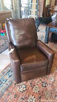 Front view of brown leather recliner on patterned rug