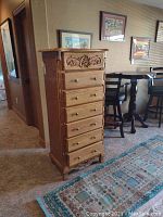 Front view of seven-drawer oak lingerie chest in room setting.