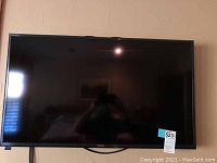 Front view of the Samsung TV mounted on the wall, showing the full screen and bezel