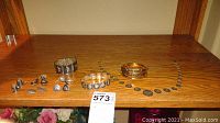 Full display of jewelry set on wooden shelf, showing necklace, bracelets, and earrings.