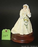 Front view of porcelain Princess Diana figurine on wood stand