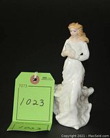 Complete view of the "Loving You" figurine showing full figure, hair blown by wind, holding a small animal.
