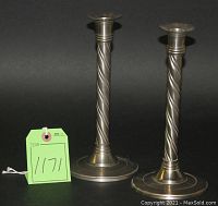 Photo showing two solid brass pewter candlesticks with twisted spiral columns on round bases.