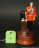 Front view of porcelain figurine and round wooden base