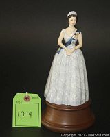 Full front view of figurine mounted on wooden stand