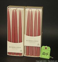 Two boxes containing pink taper candles, each box holds 8 candles, labeled Rembrandt.