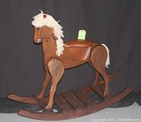 Full view of handcrafted wooden rocking horse standing on curved wooden rockers, showing brown leather seat and yarn mane and tail.