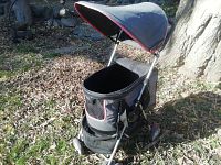 Pet stroller carrier showing the closed canopy and mesh front on a metal frame with fabric liner.