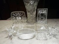 Crystal and glass vase, various dishes including pickle dishes, all clear with detailed cut patterns.