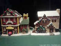Front view of ceramic Christmas fire hall and mill decorations on display, showing details and overall size.