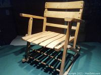 Side angle showing the full child-sized rocking chair with armrests and rockers