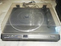 Front view of Nikko NP-800II vintage turntable with clear dust cover showing overall item including control panel and tonearm inside.