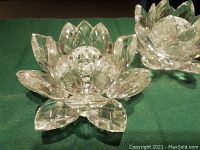 Photo showing close-up of one Swarovski crystal candle holder shaped like a lotus flower with faceted petals and central candle base.