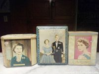 Front view of three 1953 British coronation tins featuring portraits of Queen Elizabeth II, Prince Philip, and both together. Shows colors, images, and general condition.