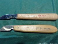 Two wooden handled wood carving tools, one marked Pfeil Swiss Made, the other Made in Germany by KST, showing handles and metal blades.