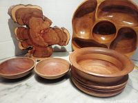 Photo showing various wooden serving pieces including round bowls and a uniquely shaped natural edge wooden serving board.