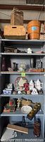 Shelf containing the vintage Sears wooden ice cream maker, wooden crates, ceramic items, books and various home decor pieces.