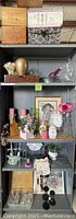 Full shelving unit showing three wooden wine crates and assorted home décor, candles, art, and crystal items.