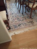 Photo of the rug under a dining table showing floral pattern and edges