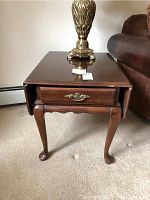 Drop leaf wooden end table with one drawer, minor scratches, antique-style metal pull, cabriole legs