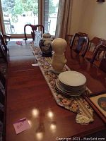 Crystal pitcher on floral table runner on dining table.