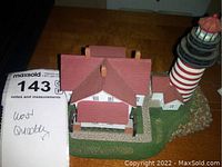 Front and side view of hand-painted West Quoddy lighthouse resin model showing post and nearby keeper's house details.
