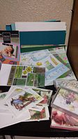Photo showing various greeting cards, sheets of scrapbook paper with colorful and seasonal themes, photo mounts and sticker sheets.